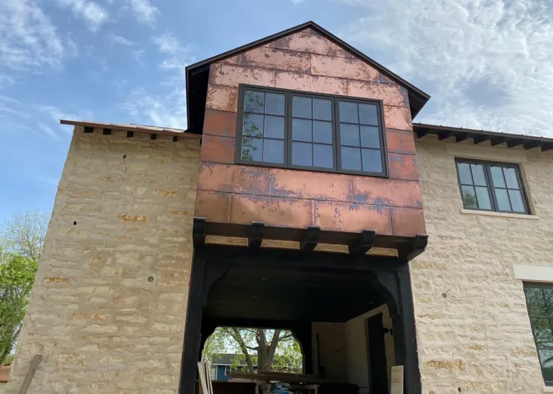 Copper metal panel facade on a stone building for Skylight Installation in Commerce